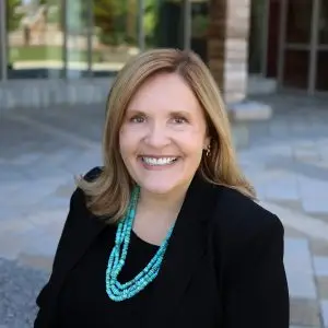 A portrait of SNHU President Lisa Marsh Ryerson sitting in front of the Wolak Library Learning Commons.