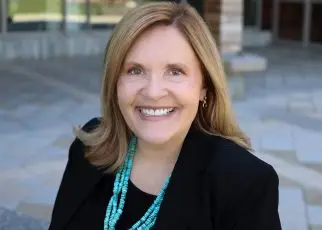 A portrait of SNHU President Lisa Marsh Ryerson sitting in front of the Wolak Library Learning Commons.