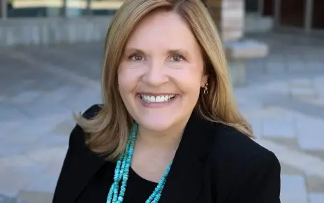 A portrait of SNHU President Lisa Marsh Ryerson sitting in front of the Wolak Library Learning Commons.